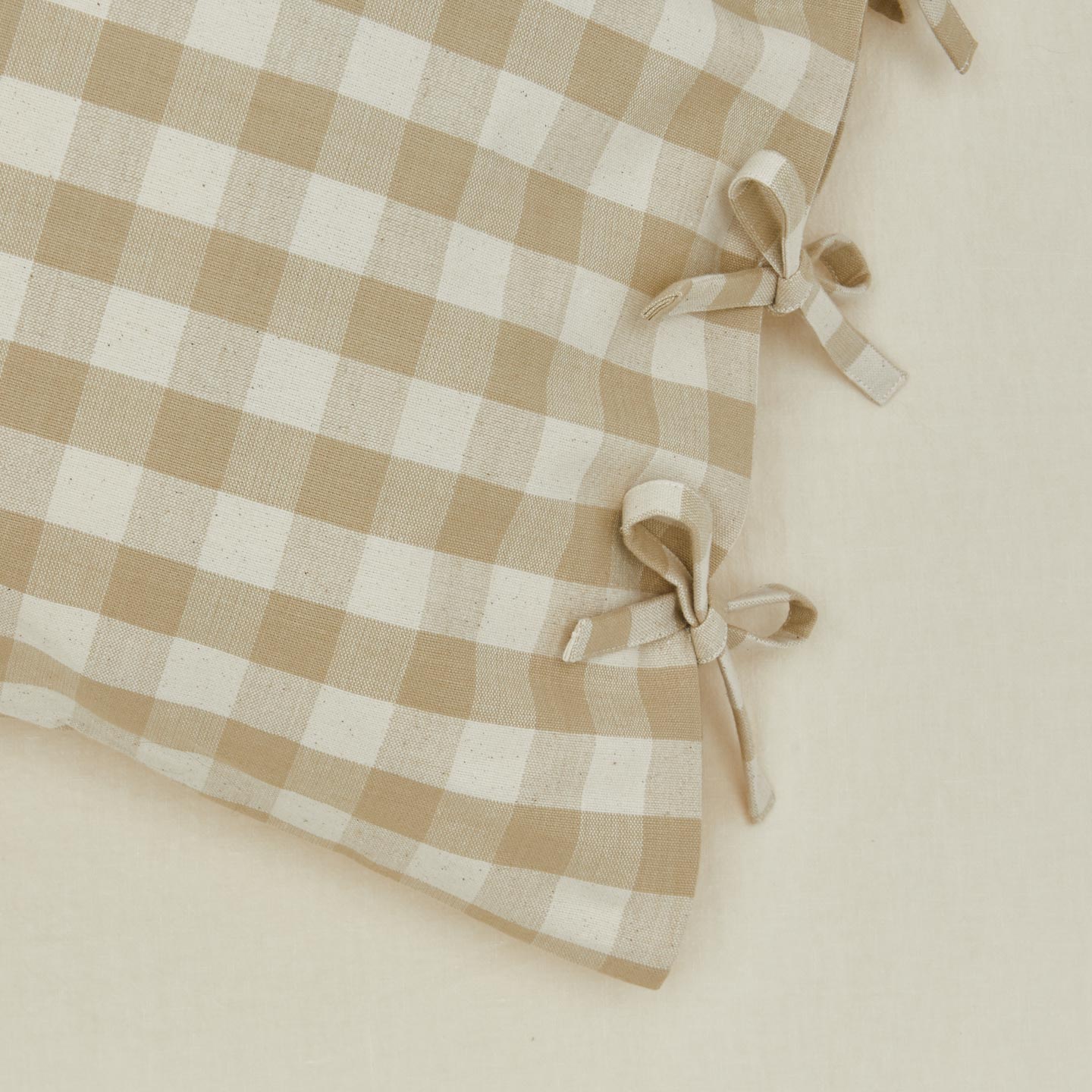 Close up view of essential gingham pillow case in ivory/flax