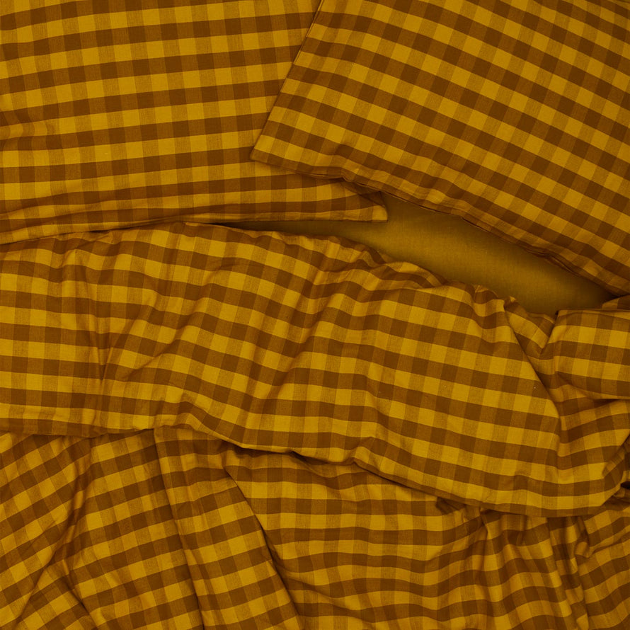 Essential Gingham Pillowcases, Set of 2 - Mustard/Bronze on bed with matching duvet
