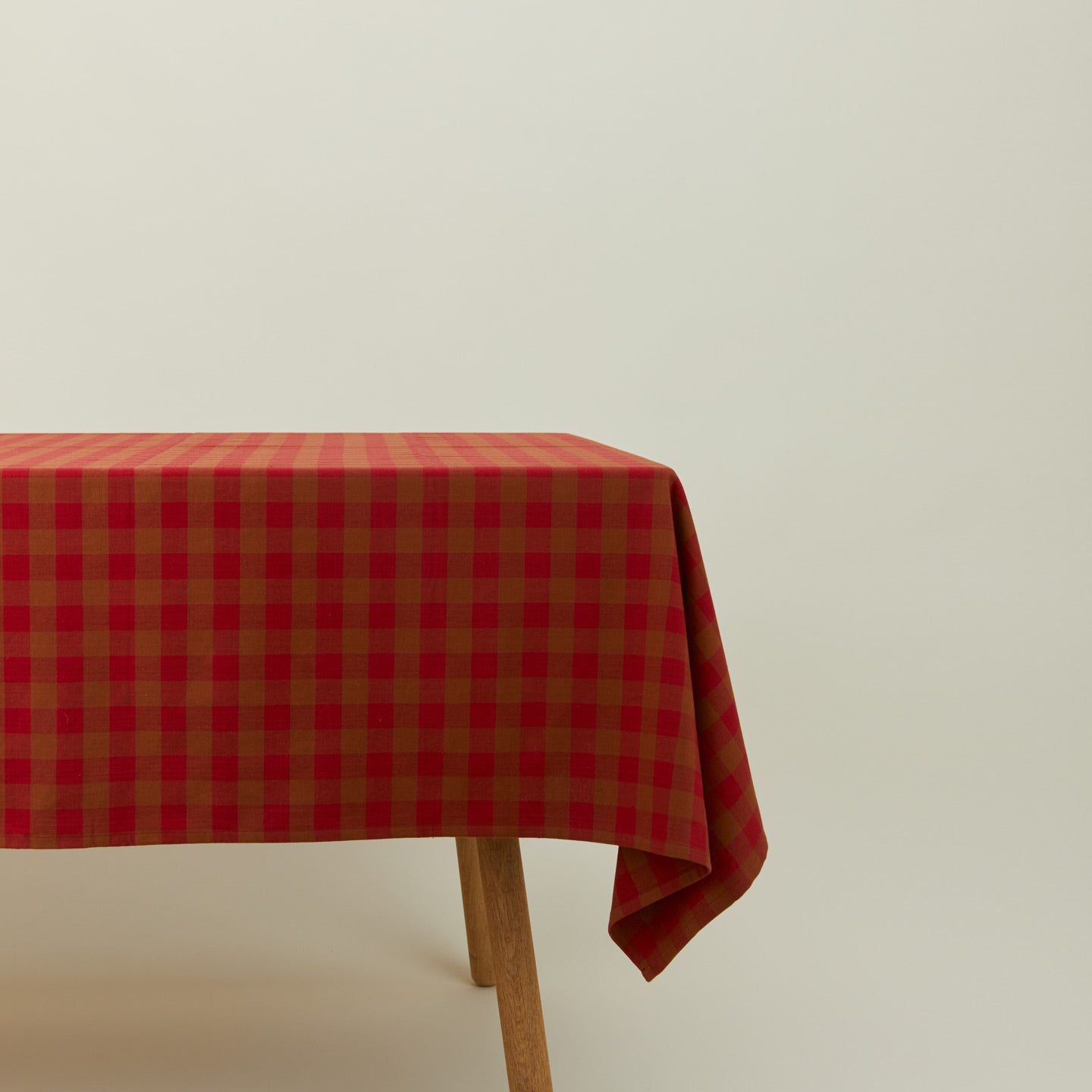 Essential Gingham tablecloth in red/terracotta on a table.