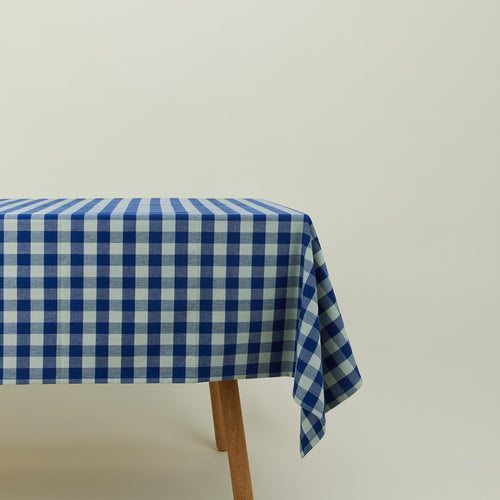 Essential Gingham tablecloth in sky/blue on a table.