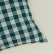 Close up view of gingham square pillow in sky/peacock