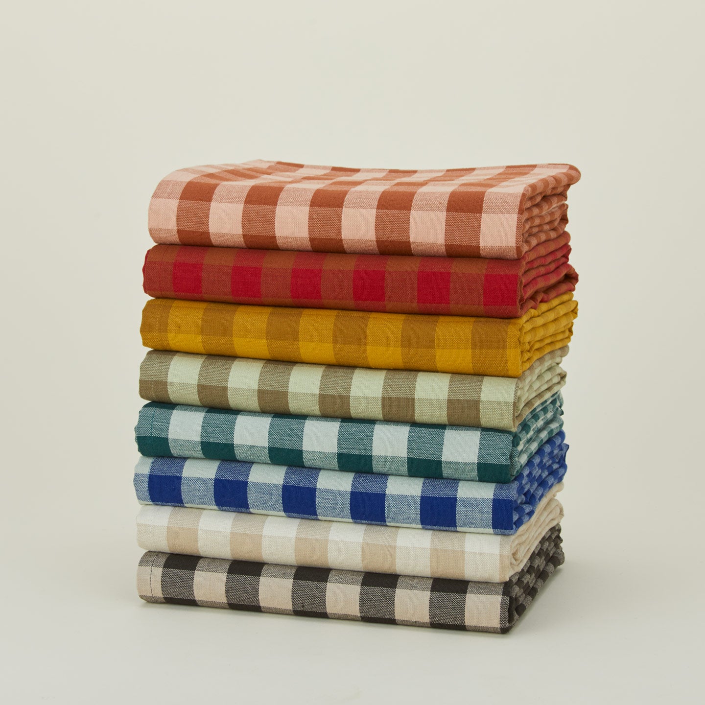 Stack of Essential Gingham tablecloths in various colors