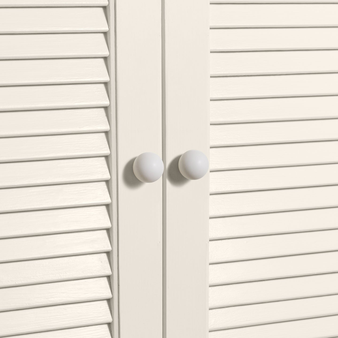 Small ivory essential sphere knobs on louvered doors