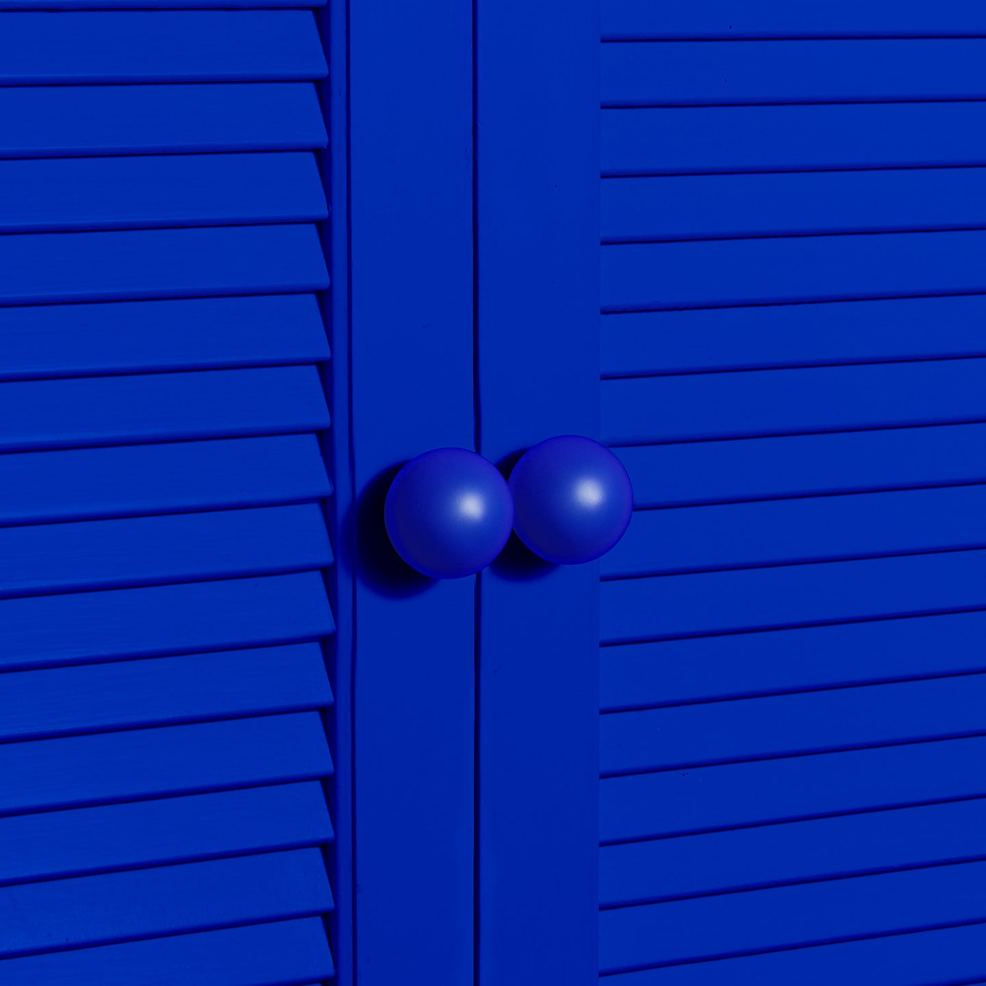 Large sphere knobs in klein blue on cabinet