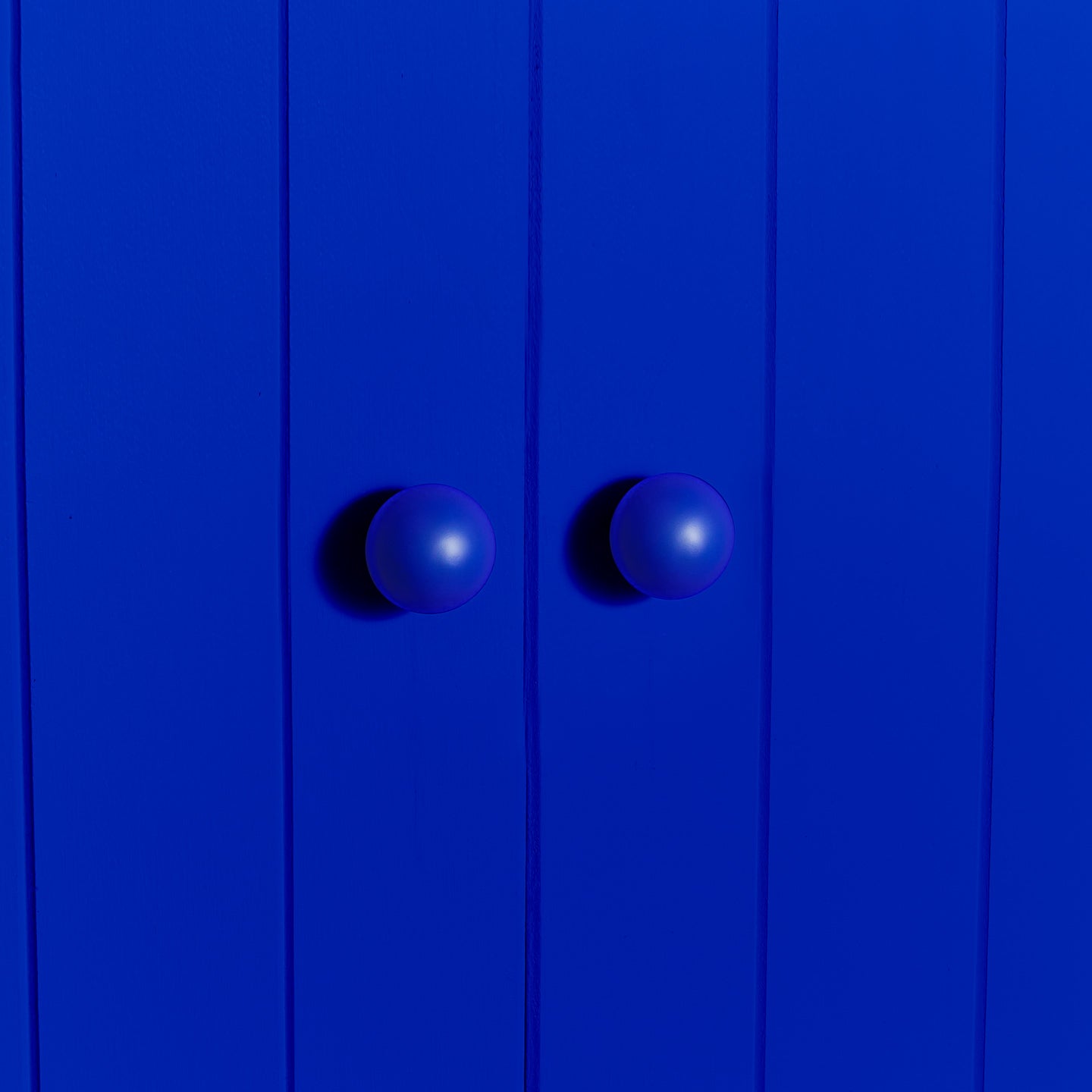 Large essential sphere knobs in klein blue on cabinet door 