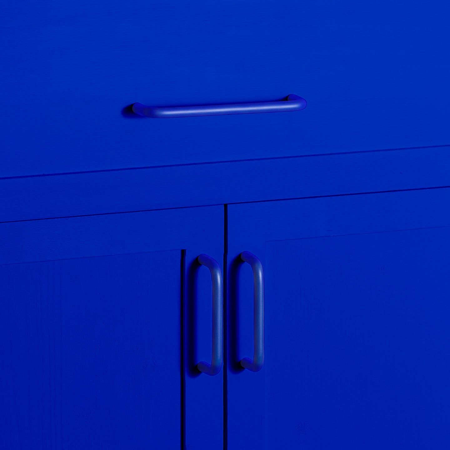 Large and small essential drawer pulls in klein blue on cabinet