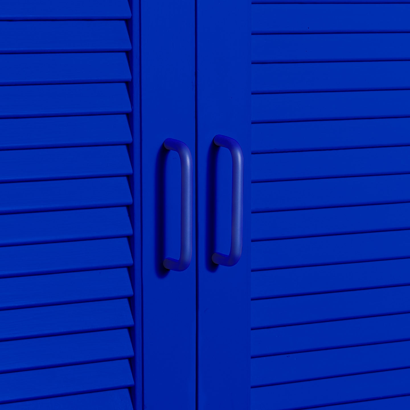 Small essential drawer pulls in klein blue on cabinet