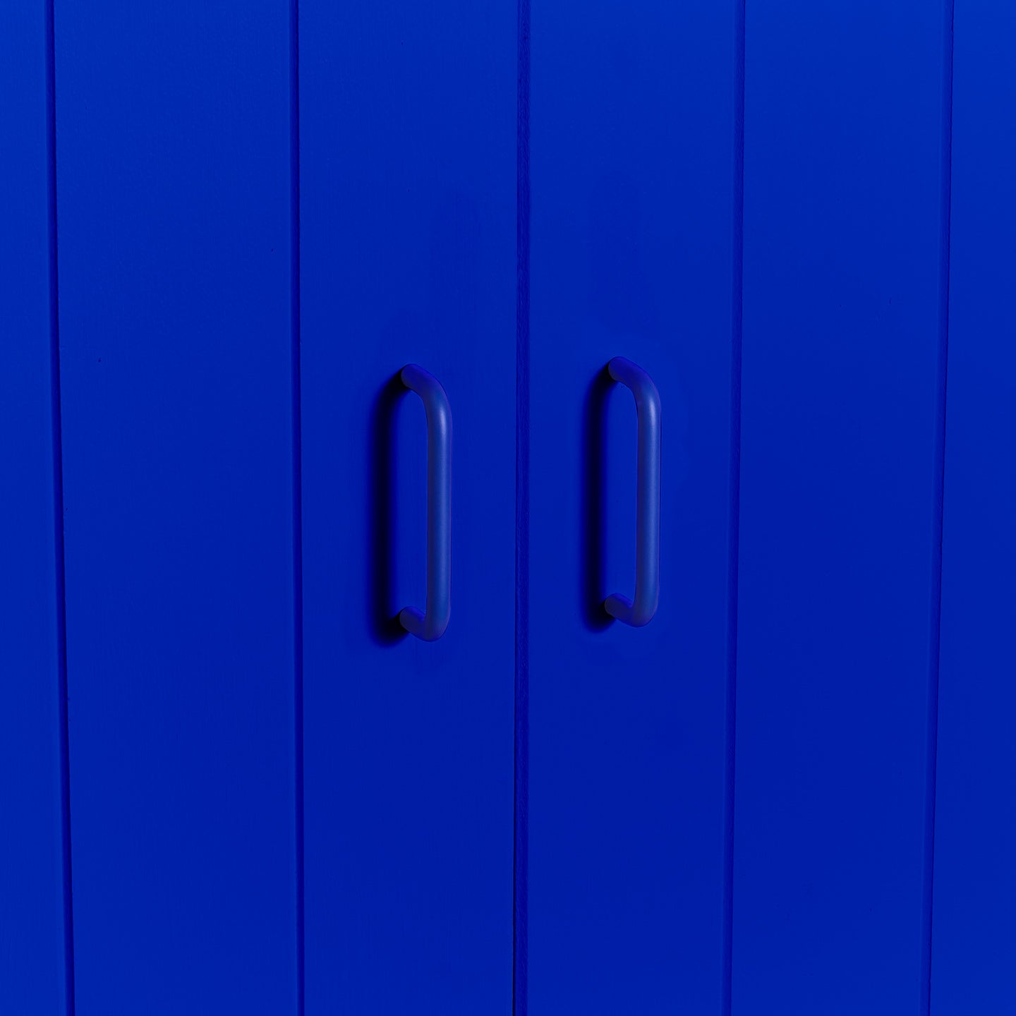 Small essential drawer pull in klein blue on cabinet