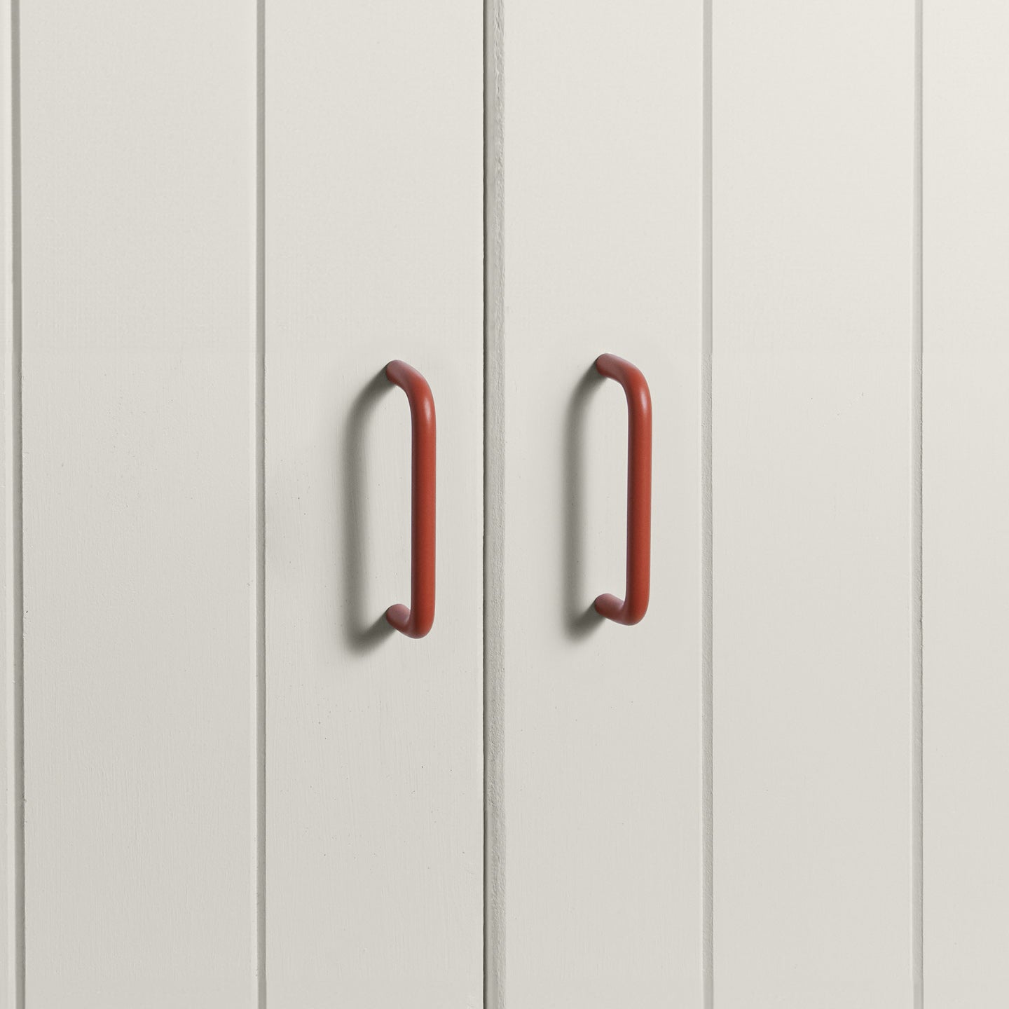 Small terracotta pulls on white doors