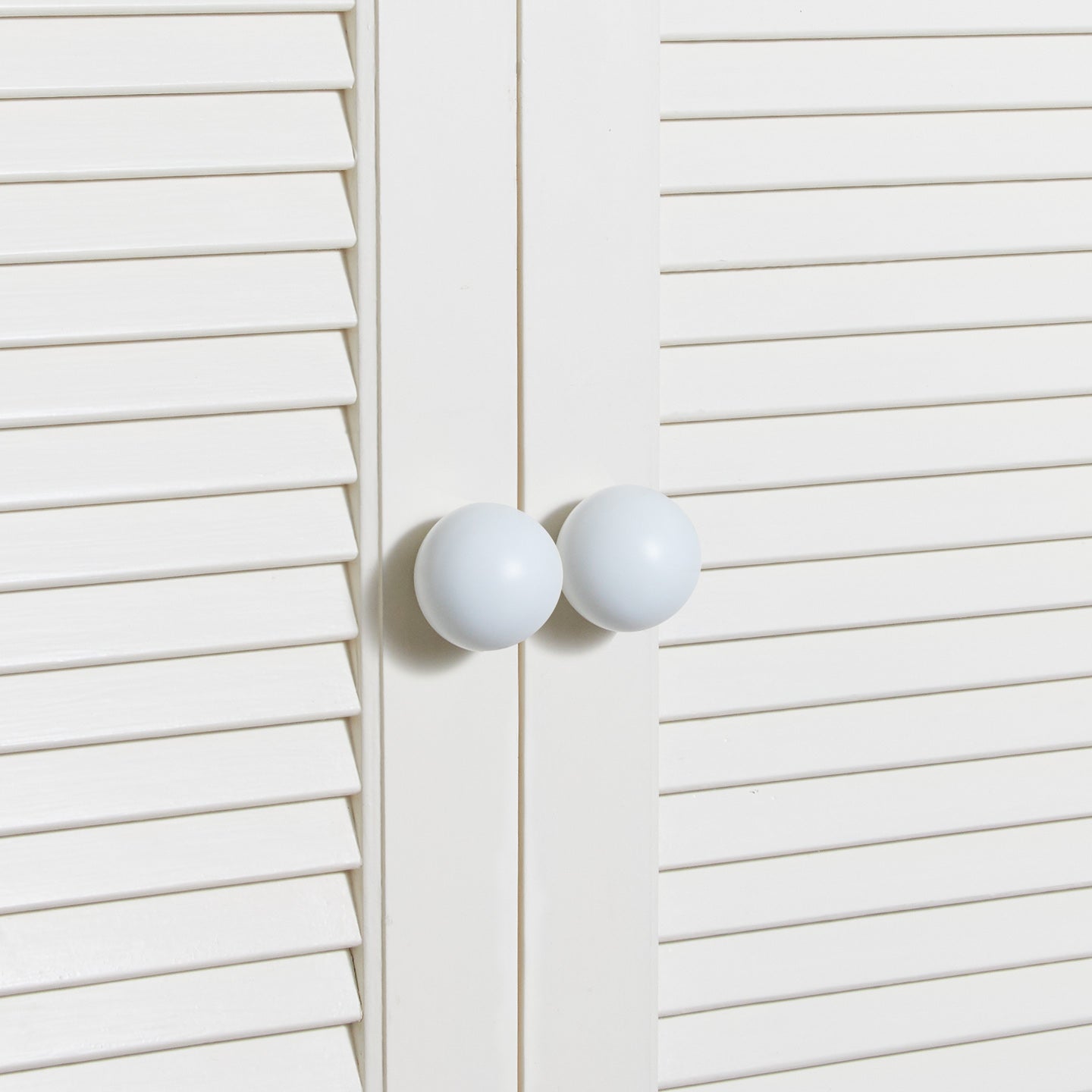 Large essential knobs in white on cabinet