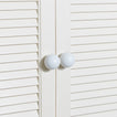 Large essential knobs in white on cabinet