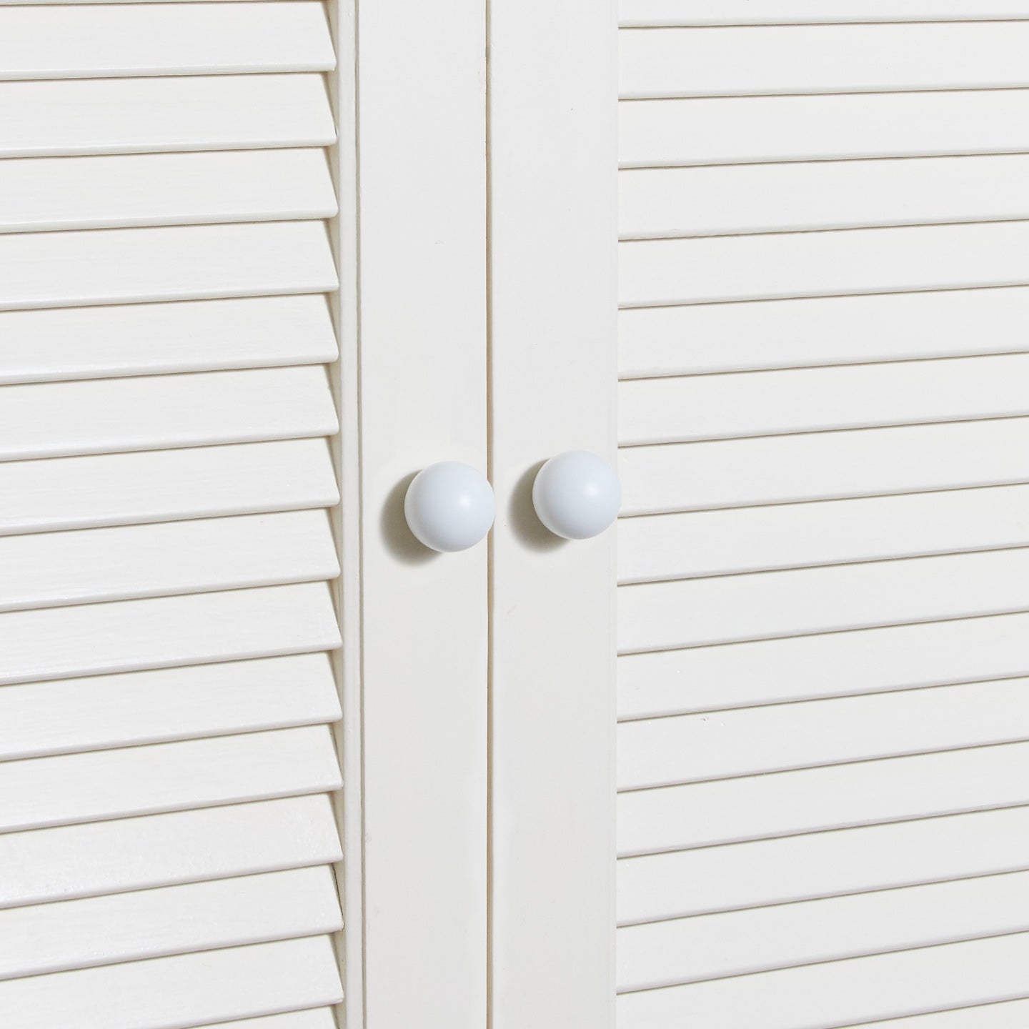 Small essential knobs in white on cabinet doors