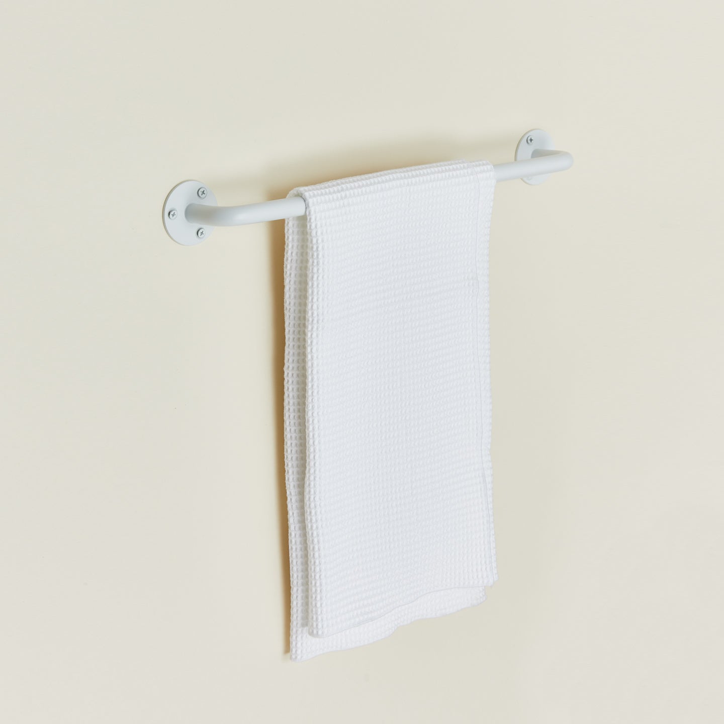 Essential towel bar in white with towel.