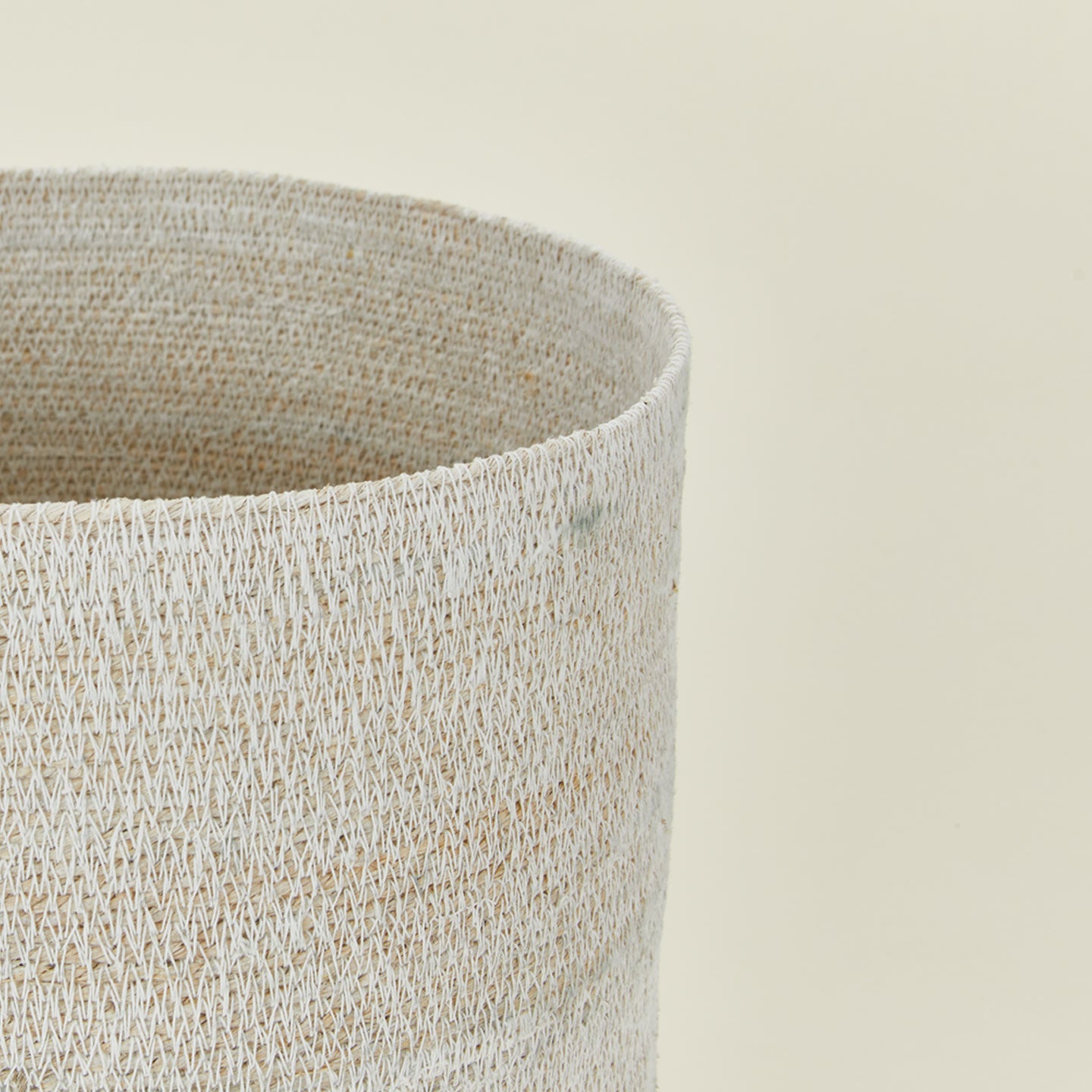 Close up view of essential woven wastebasket in various colors