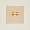 Brass garlic rocker on beige background.