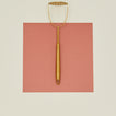 Brass potato masher on pink paper
