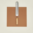 Zester with wooden handle on a brown paper against a beige background