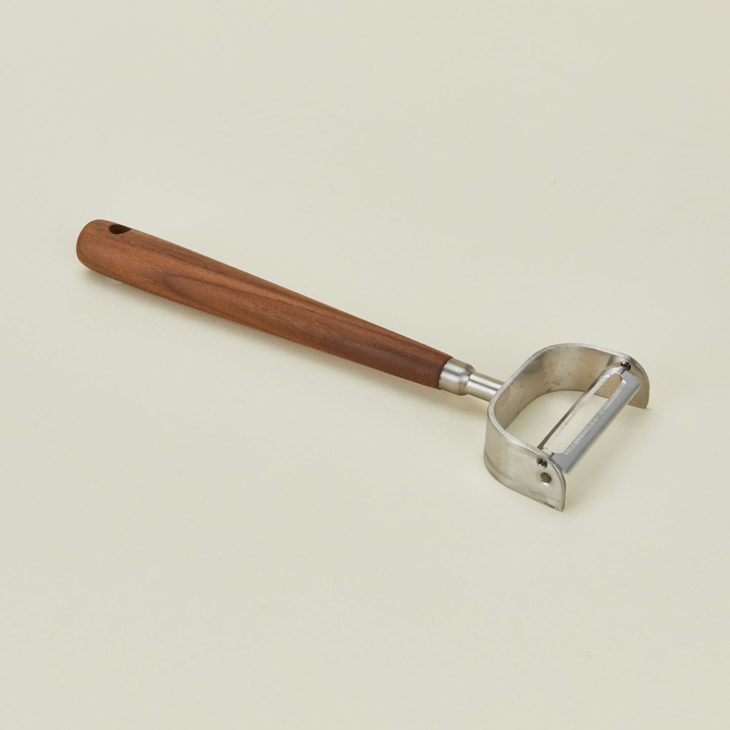 Detailed view of walnut handled vegetable peeler 