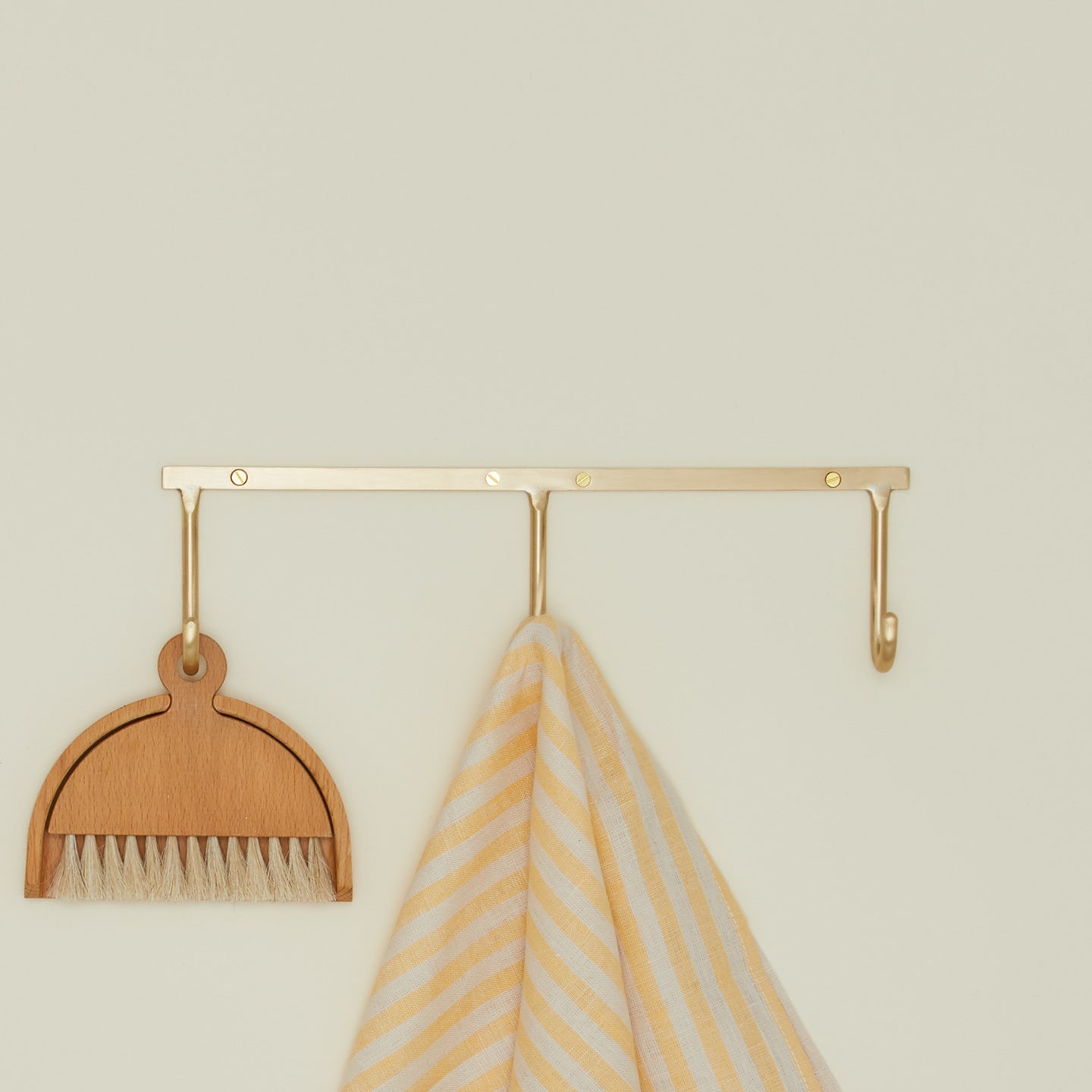 Brass hook rack trio with towels and brush with dustpan