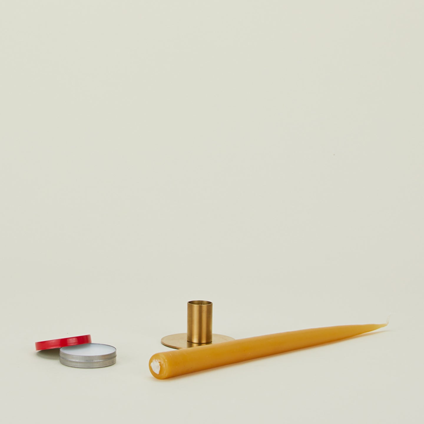 Stick um candle adhesive applied to yellow candle with brass candle holder