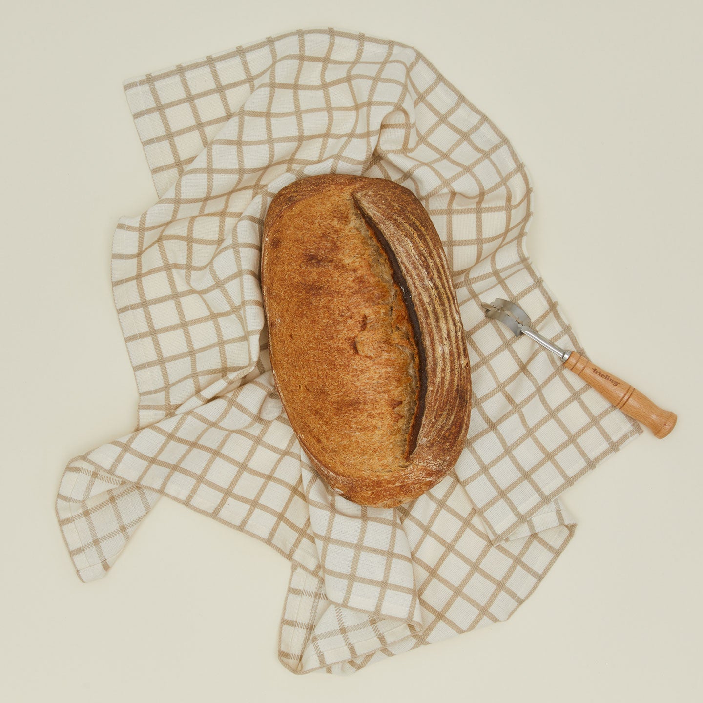 Frieling bread lame with a loaf of bread and kitchen towel