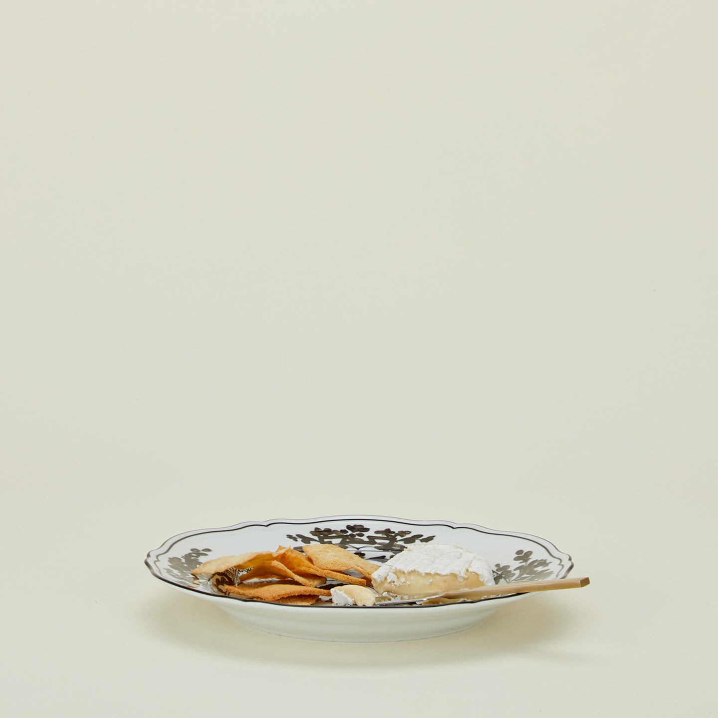 Ginori dinner plate in albus with cheese knife, brie, and crackers