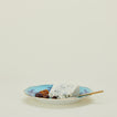 Ginori dinner plate in iris with cheese knife, cheese, and olives