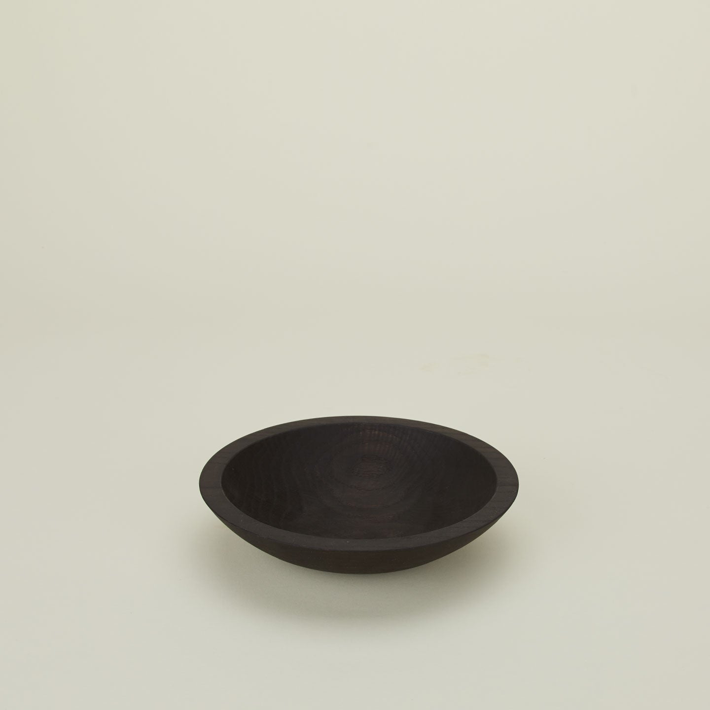 A close up  of a 9” ebonized oak  wood bowl.