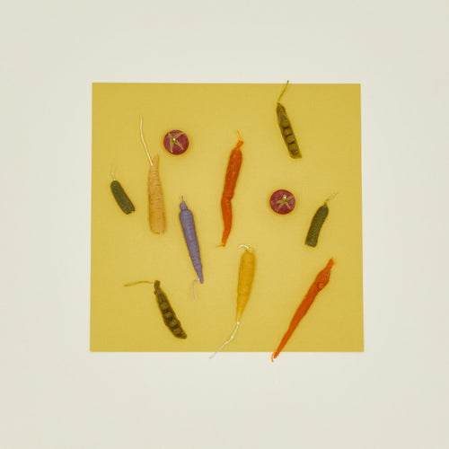 Colorful vegetable candles on a yellow background