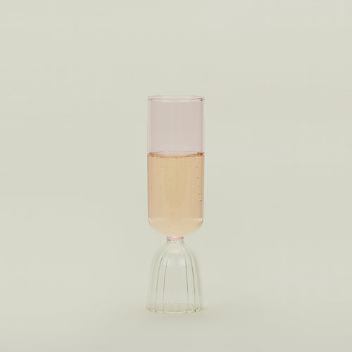 Flute glass with clear stem and pink cup, filled with sparkling wine.