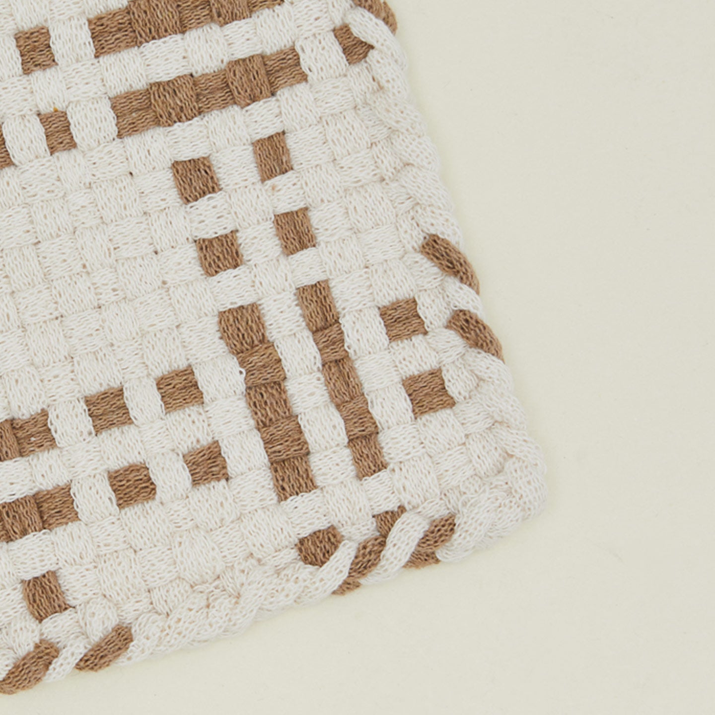Detail view of dots and dashes potholder in white and flax