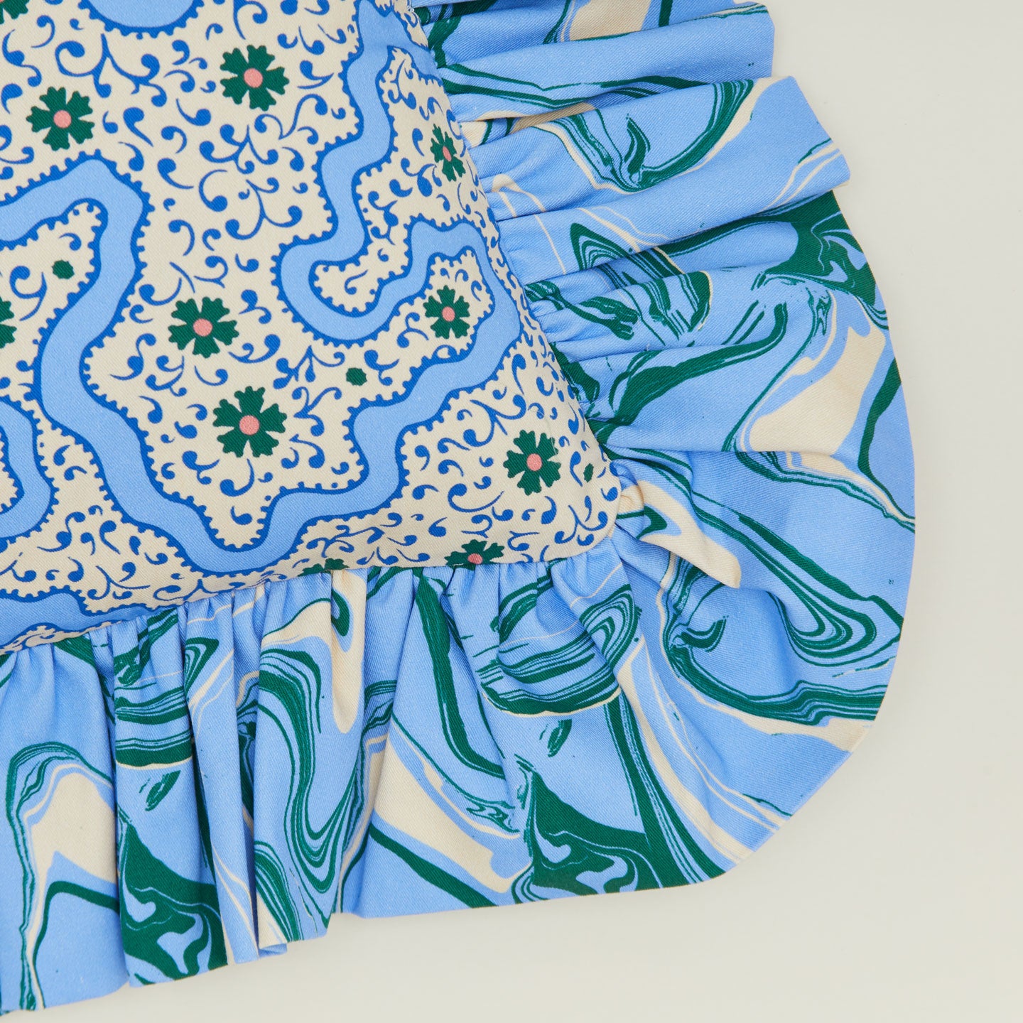 A close up of a ruffled floral cushion with a cornflower pattern.
