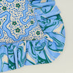 A close up of a ruffled floral cushion with a cornflower pattern.