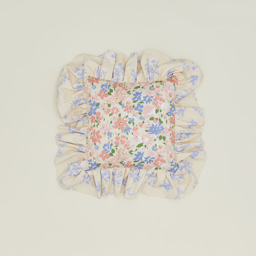 A ruffled floral cushion with a rose pattern.