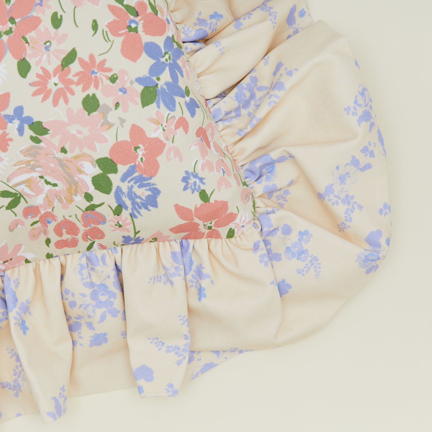 A close up of a ruffled floral cushion with a rose pattern.