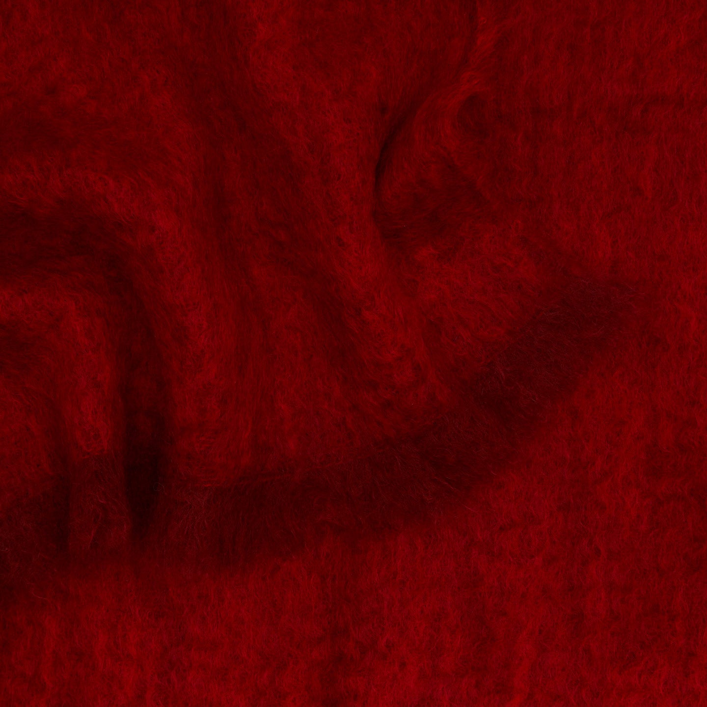 Close up view of solid mohair throw in red