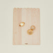 Overhead view of large scalloped cutting board with onions