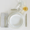 Placesetting with Modernist Dinner Plate on ivory striped tablecloth.