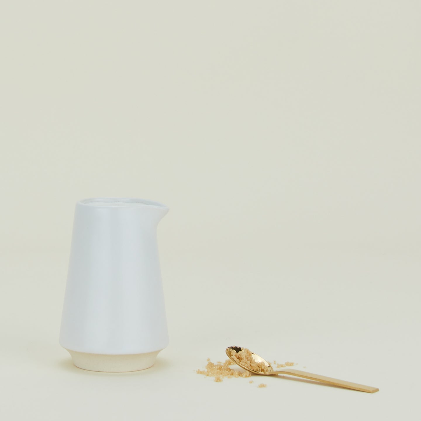 Modernisth Pitcher with small sugar spoon.