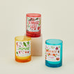 Three colorful candles with labels on a beige background
