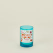 Blue candle with a decorative label on a light beige background