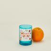 Blue candle labeled 'Orange Blossom' next to an orange on a beige background