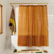 Sun grid shower curtain in honey in bathroom