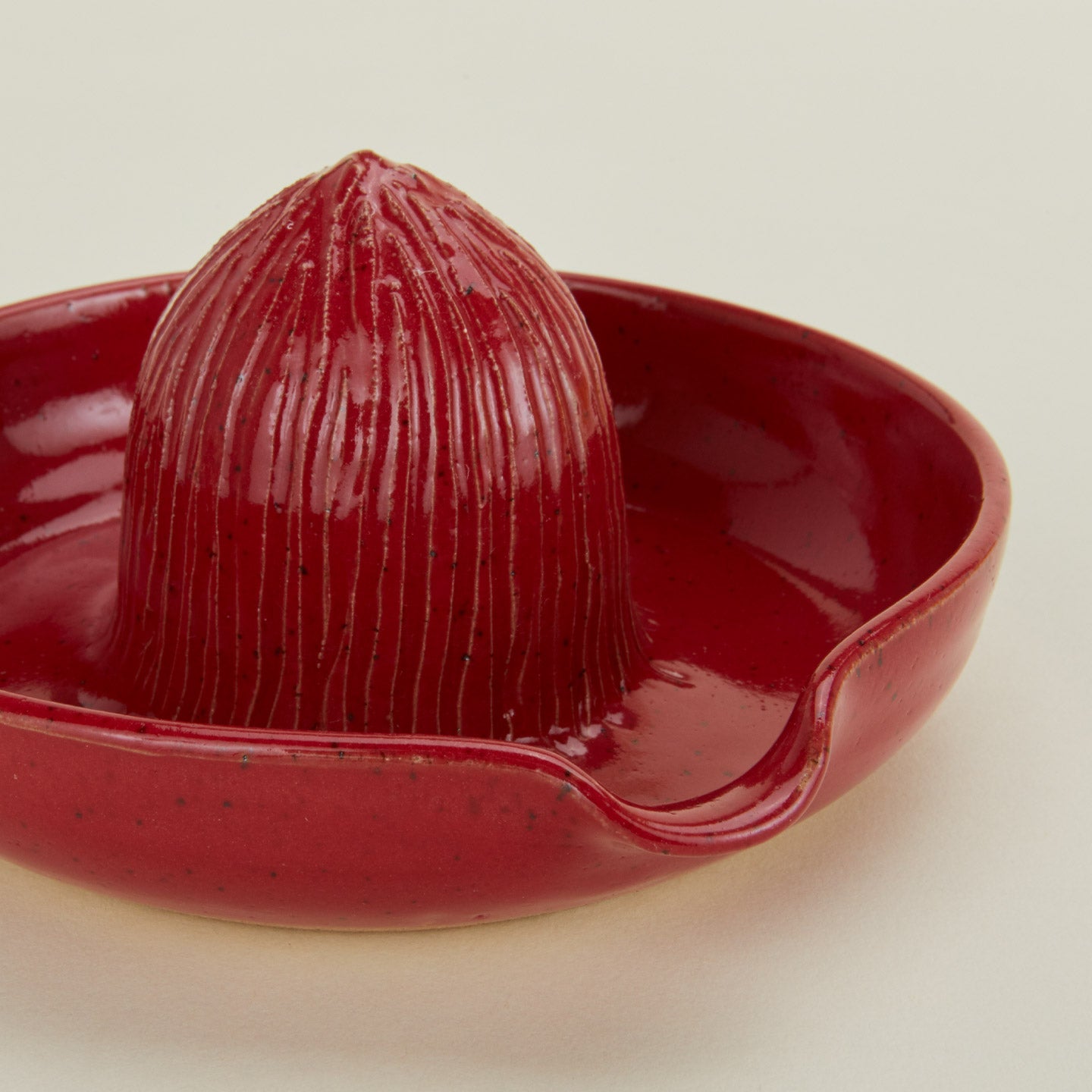 Close up of stoneware citrus juicer in Coral.