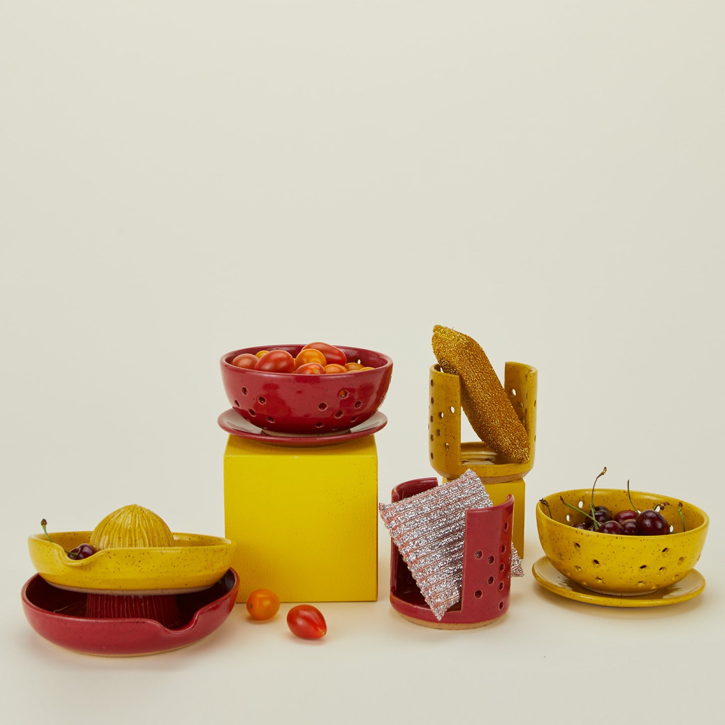 Group shot of stoneware pieces in Yellow and Coral in various styles.
