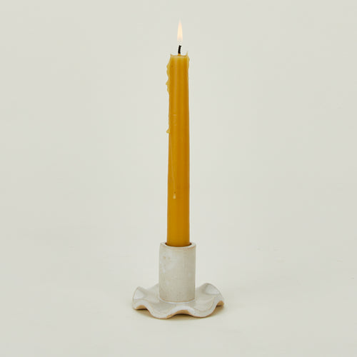 Ruffle edge candle holder with lit beeswax candle