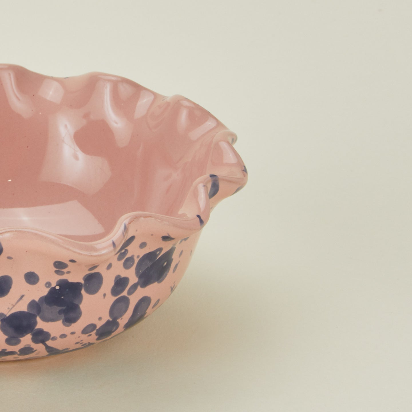 Close up view of Splatter scallop bowl in pink and blue