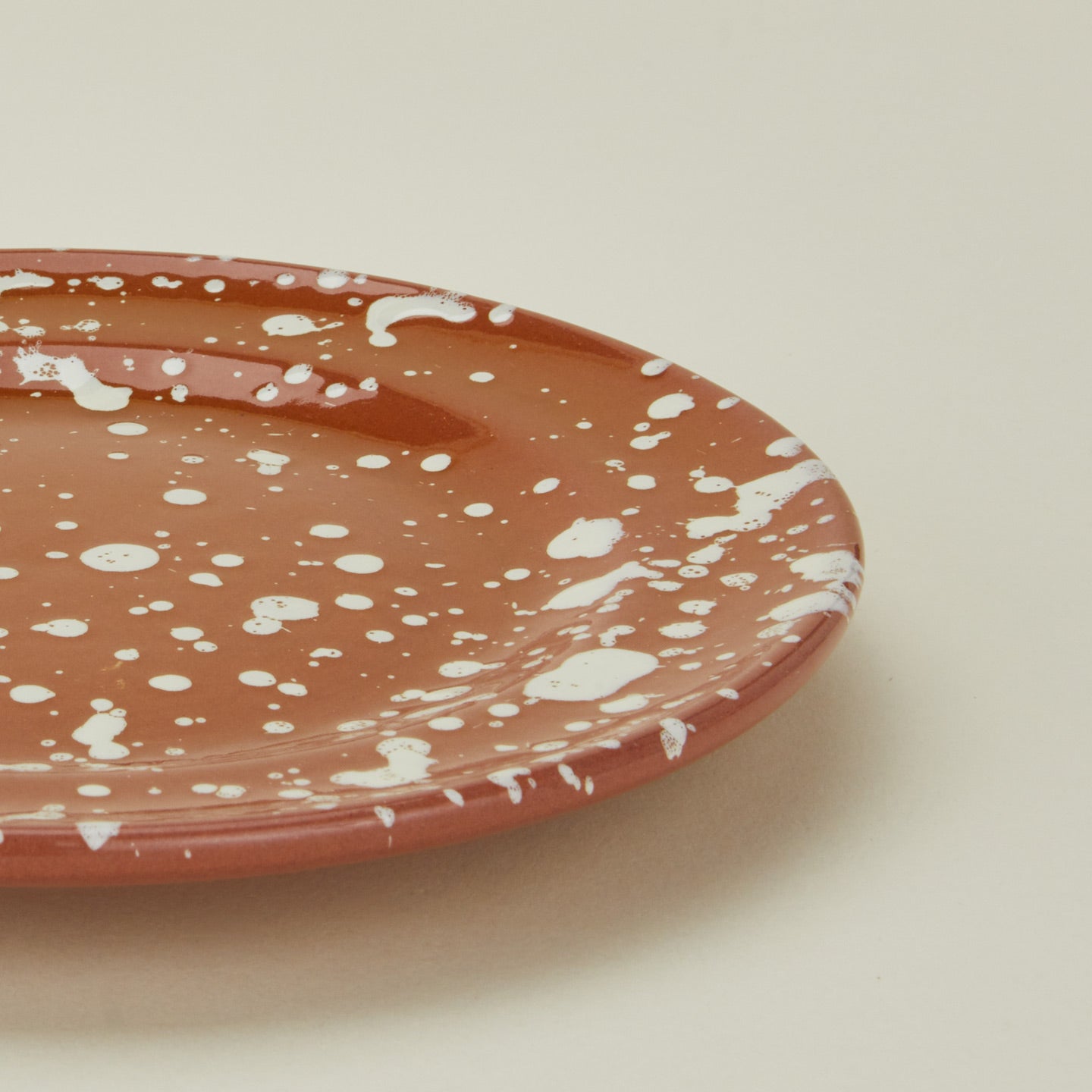 Close up view of Splatter terracotta and ivory salad plate