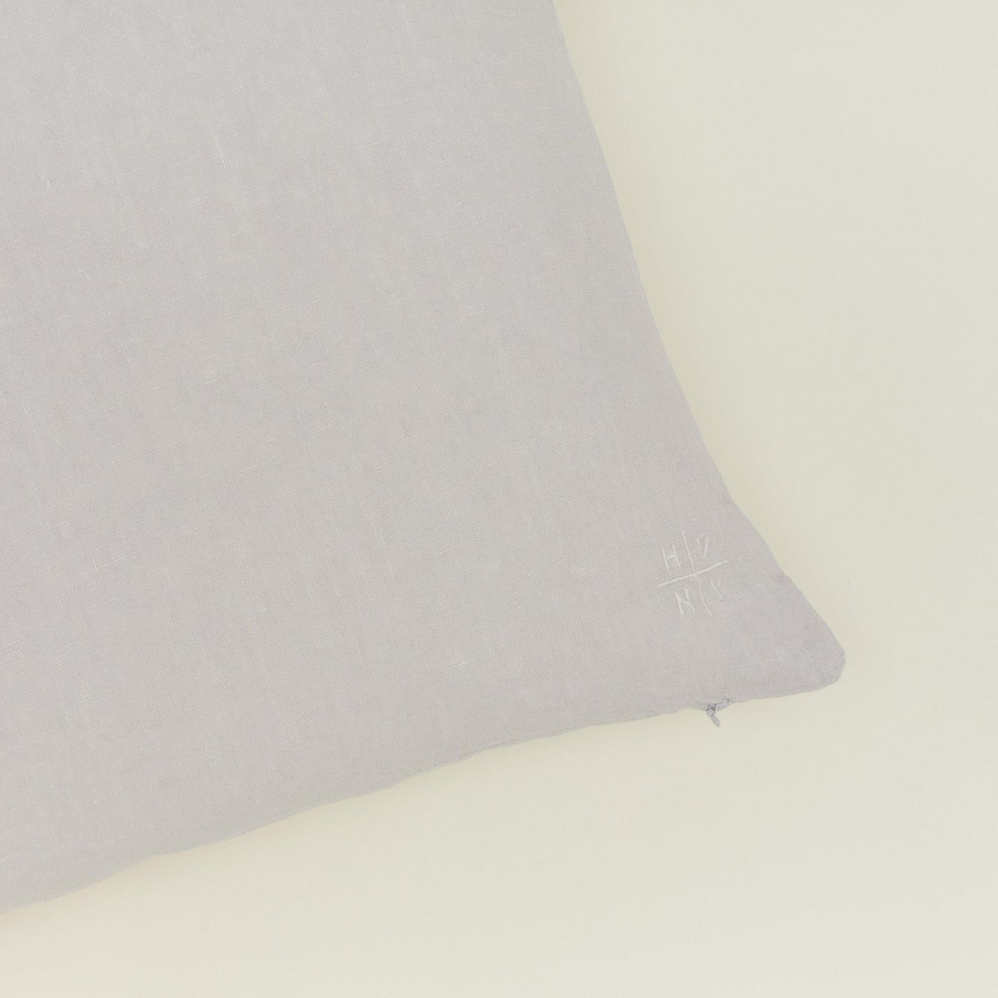 Close up view of simple linen pillow in light grey