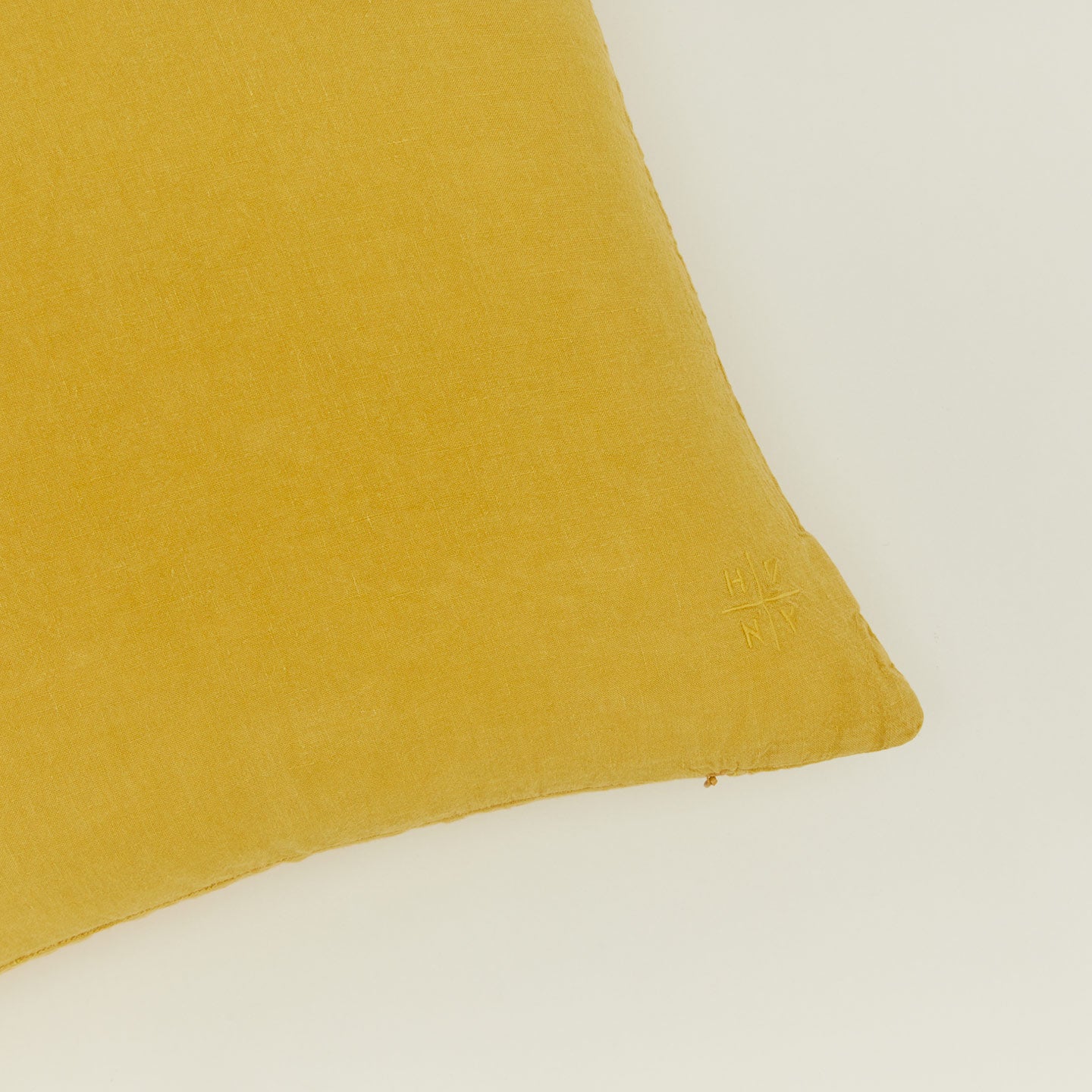 Close up view of simple linen pillow in mustard